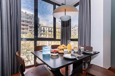 a dining room with a table and a large window at Sweett - Casa Roma in Barcelona