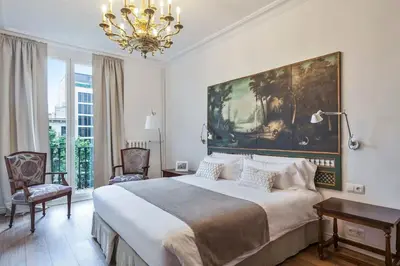 a bedroom with a large bed and a chandelier at The Collection Barcelona - Casa Batlló - Luxury Historic 4BD 4BTH for 9 guests in Barcelona