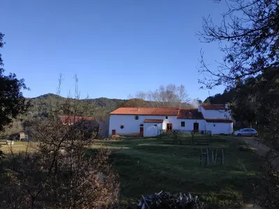 a white house with a car parked in front of it at Mas Can Puig de Fuirosos ONLY ADULTS in La Batlloria
