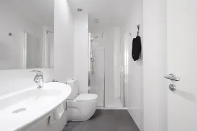 a white bathroom with a toilet and a shower at Numa Barcelona Colmena in Barcelona