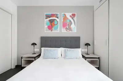 a bedroom with a large white bed with two tables at Numa Barcelona Colmena in Barcelona