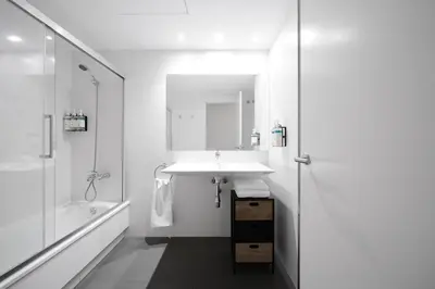 a white bathroom with a sink and a shower at Numa Barcelona Colmena in Barcelona