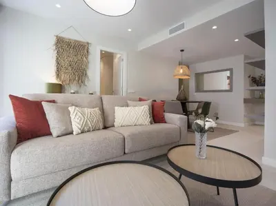 a living room with a couch and two tables at Sitges Spaces Deluxe Comfort Flat-Monthly Rentals in Sitges