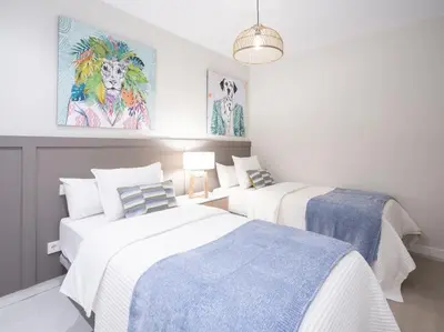 a bedroom with two beds and a painting on the wall at Sitges Spaces Deluxe Comfort Flat-Monthly Rentals in Sitges