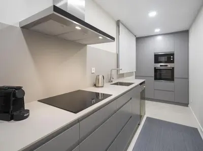 a white kitchen with a sink and a stove at Sitges Spaces Deluxe Comfort Flat-Monthly Rentals in Sitges
