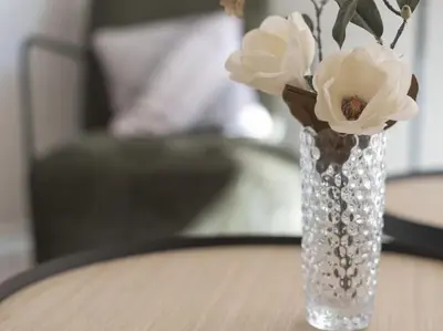 a glass vase with white flowers sitting on a table at Sitges Spaces Deluxe Comfort Flat-Monthly Rentals in Sitges