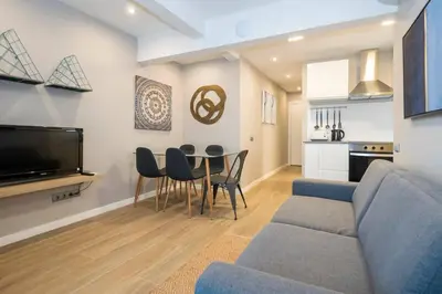 a living room with a couch and a table and chairs at BeBarceloner Sant Andreu Apartments - 3 bedrooms with terrace in Barcelona