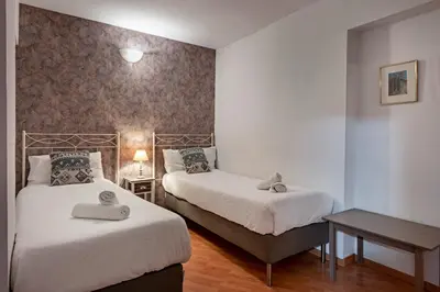 a bedroom with two beds and a table with a lamp at Habitat Apartments Ribes in Barcelona