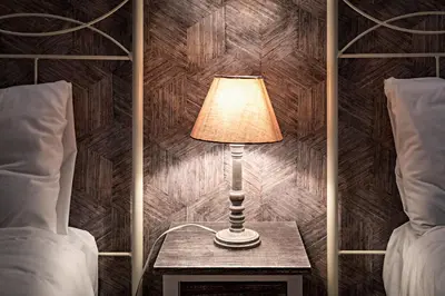 a lamp on a table next to two beds at Habitat Apartments Ribes in Barcelona