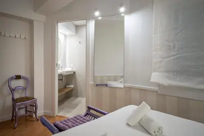 a room with a bed and a chair and a mirror at Habitat Apartments Ribes in Barcelona