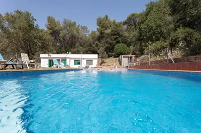 a large pool with blue water in front of a house at Cottage Eco-Friendly Barcelona country side in La Garriga