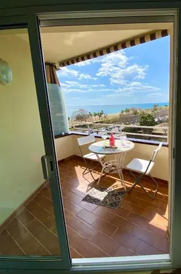 a patio with a table and chairs on a balcony at Apart. Pineda de Mar-Sea and mountains views in Pineda de Mar