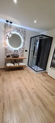 a bathroom with a large mirror and a wooden floor at HOTEL MANEL in Martorell