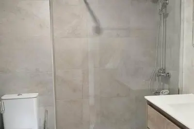 a bathroom with a shower with a toilet and a sink at HHBCN Beach Apartment Castelldefels #3 in Castelldefels