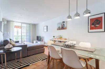 a living room with a table and chairs and a couch at HHBCN Beach Apartment Castelldefels #3 in Castelldefels
