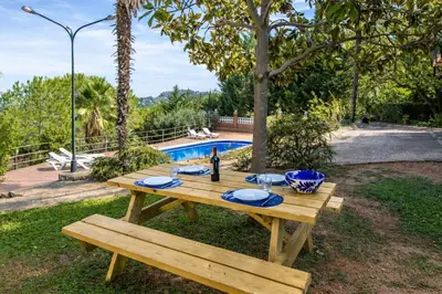 a wooden picnic table with a bottle of wine on it at Catalunya Casas Elegant Mountain Villa just 30km to Barcelona in Corbera de Llobregat