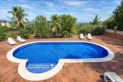 a swimming pool on a patio with lounge chairs around it at Catalunya Casas Elegant Mountain Villa just 30km to Barcelona in Corbera de Llobregat