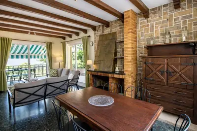 a living room with a wooden table and a fireplace at Catalunya Casas Elegant Mountain Villa just 30km to Barcelona in Corbera de Llobregat