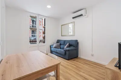 a living room with a blue couch and a table at AB Nou de la Rambla in Barcelona