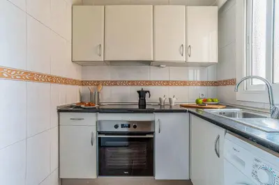 a kitchen with white cabinets and a sink at AB Nou de la Rambla in Barcelona