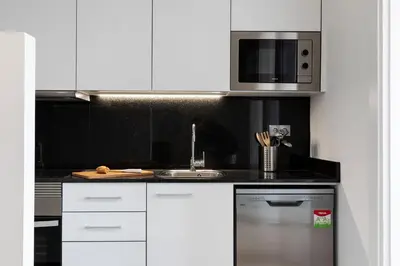 a kitchen with white cabinets and a stainless steel refrigerator at AB Comte d'Urgell - 2975 in Barcelona