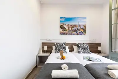 a bedroom with two beds and a painting on the wall at AB Comte d'Urgell - 2975 in Barcelona