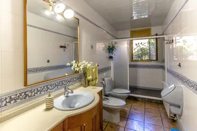 a bathroom with a sink and a toilet and a mirror at Catalunya Casas Spacious, Sublime Villa just 15km to Barcelona! in Torrelles de Llobregat