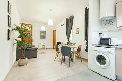 a kitchen and living room with a table and a washing machine at The Collection Barcelona - Comfortable 3BD in Poblenou next to the beach only for Families! in Barcelona