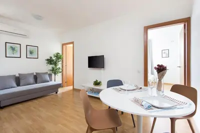 a living room with a table and a couch at The Collection Barcelona - Sunny 3BD only for Families in Poblenou next to the sea! in Barcelona