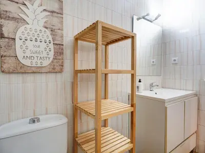 a bathroom with a wooden shelf next to a sink at Charming Patio by Hello Homes Sitges in Sitges
