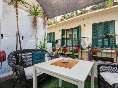 a white table and chairs on a balcony with plants at Charming Patio by Hello Homes Sitges in Sitges