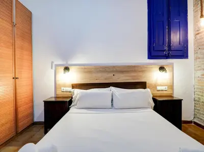 a bedroom with a large white bed with blue cabinets at Charming Patio by Hello Homes Sitges in Sitges