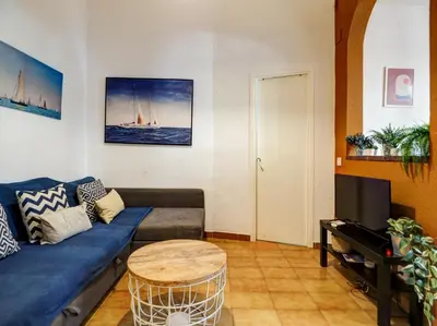 a living room with a blue couch and a table at Charming Patio by Hello Homes Sitges in Sitges
