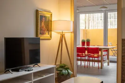 a living room with a television and a table with chairs at Stay U-nique Apartment Maurici Serrahima in Barcelona