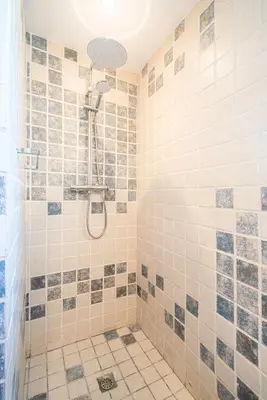 a bathroom with a shower with tiled walls at Winahost Casa familiar con piscina in Santa Eulalia de Ronsaná