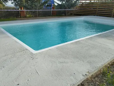 a swimming pool with blue water in a yard at Winahost Casa familiar con piscina in Santa Eulalia de Ronsaná