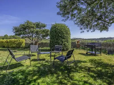 a group of chairs and a piano in the grass at Winahost Casa familiar con piscina in Santa Eulalia de Ronsaná