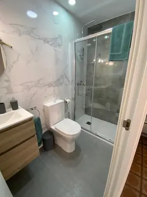 a bathroom with a toilet and a glass shower at La Casa Vella EL BEDORC in Piera