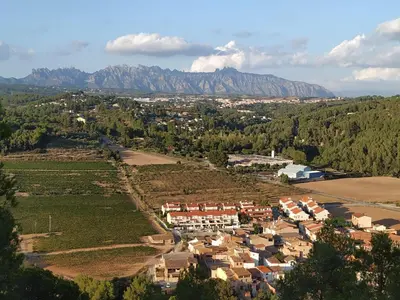 an aerial view of a village with mountains in the background at La Casa Vella EL BEDORC in Piera