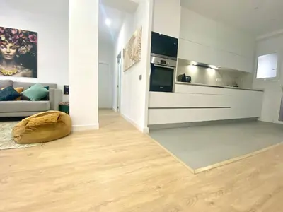 a living room with a couch and a kitchen at Barcelona Chic Apartments- Free Parking - 10 min BCN center by metro in Barcelona