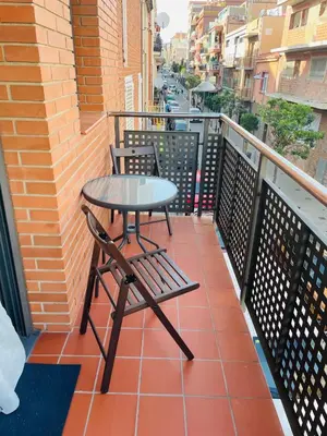a small table and chairs on a balcony at Beach Apartment Artigas in Badalona
