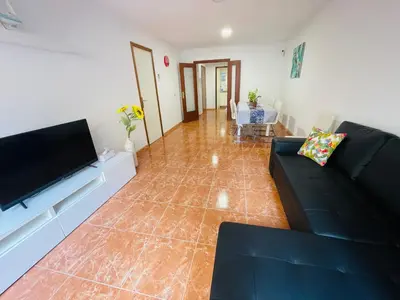 a living room with a couch and a flat screen tv at Beach Apartment Artigas in Badalona