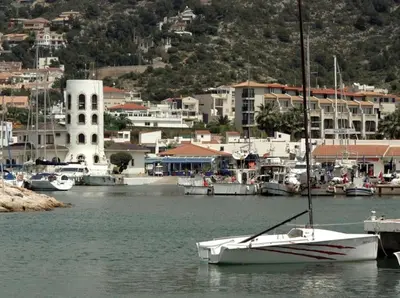 a white boat docked in a harbor with buildings at Marina Beach Aiguadolç Sitges in Sitges