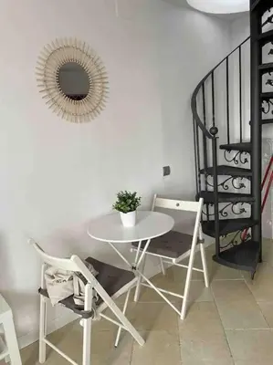 a table and chairs in a room with a mirror at Marina Beach Aiguadolç Sitges in Sitges