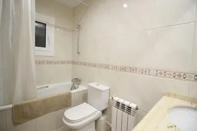 a white bathroom with a toilet and a sink at Nice new apartment only 30min to Barcelona center. in Granollers