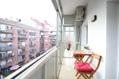 a balcony with a table and red cushioned chairs at Nice new apartment only 30min to Barcelona center. in Granollers
