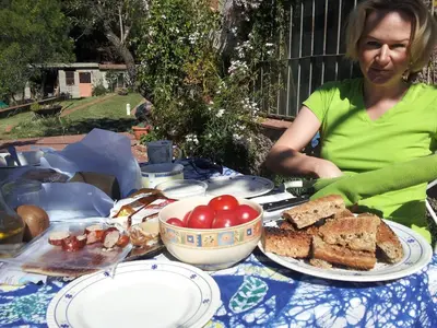a woman sitting at a table with a plate of food at MASIA CAN SUNYER AGROTURISMO in La Garriga
