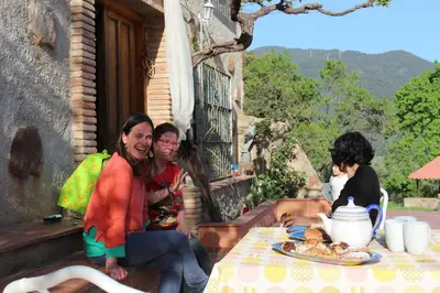 a group of people sitting at a table with food at MASIA CAN SUNYER AGROTURISMO in La Garriga