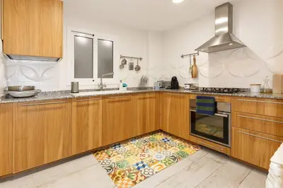 a kitchen with wooden cabinets and a rug on the floor at Excelente ubicación en Vilafranca del Penedes in Vilafranca del Penedès