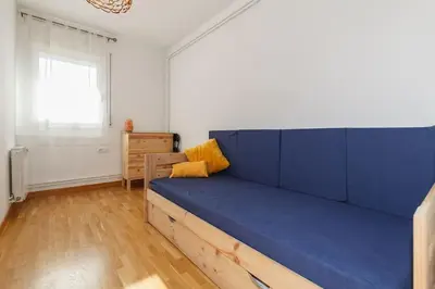 a large blue couch in a room with a window at Excelente ubicación en Vilafranca del Penedes in Vilafranca del Penedès